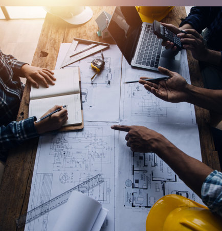 Two Specialists Inspect Commercial, Industrial Building Construction Site. Real Estate Project with Civil Engineer, Investor Use Laptop. In the Background Crane, Skyscraper Concrete Formwork Framesの写真素材