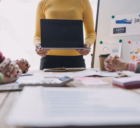 Financial analysts analyze business financial reports on a digital tablet planning investment project during a discussion at a meeting of corporate showing the results of their successful teamwork.の写真素材