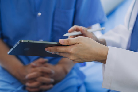 Doctor telling to patient woman the results of her medical tests. Doctor showing medical records to cancer patient in hospital ward. Senior doctor explaint the side effects of the intervention.の写真素材