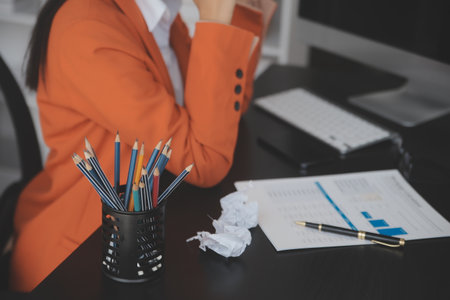 Attractive smiling young asian business woman work at home office, Asian woman working on laptop computer holding tablet.の写真素材