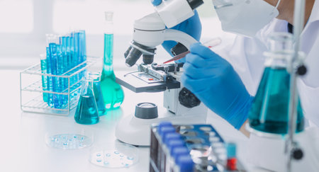Medical Development Laboratory: Caucasian Female Scientist Looking Under Microscope, Analyzes Petri...