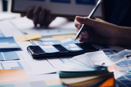 Close up ux developer and ui designer brainstorming about mobile app interface wireframe design on...