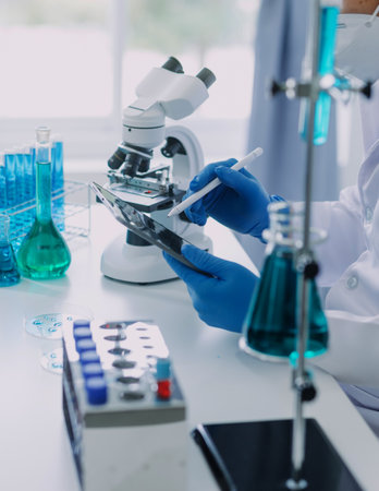 hand of scientist with test tube and flask in medical chemistry lab blue banner backgroundの写真素材