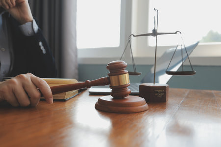 Business and lawyers discussing contract papers with brass scale on desk in office. Law, legal services, advice, justice and law concept picture with film grain effectの写真素材