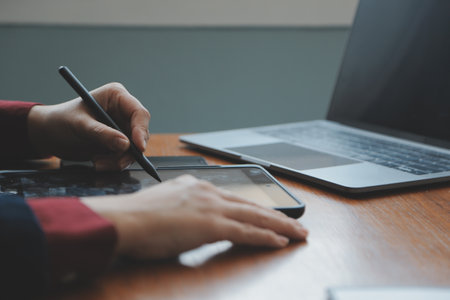 Asian Businesswoman Using laptop computer and working at office with calculator document on desk,...