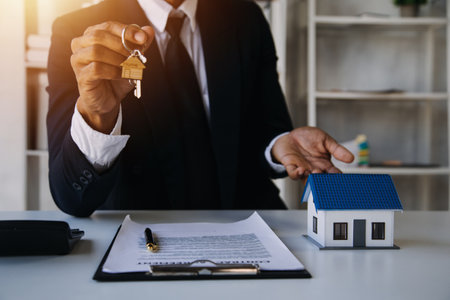 Accountant, businessman, real estate agent, Asian business woman handing keys to customers along with house after customers to signの写真素材