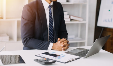 Woman accountant use calculator and computer with holding pen onの写真素材