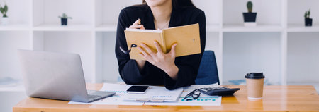 Close up of accountant working and analyzing financial reports project accounting with chart graph and calculator in modern office : finance and business concept.の写真素材