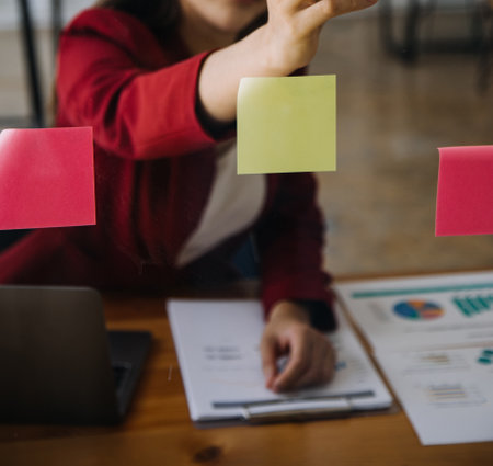 Close up of accountant working and analyzing financial reports project accounting with chart graph and calculator in modern office : finance and business concept.の写真素材