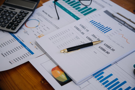 Asian Business woman using calculator and laptop for doing math finance on an office desk, tax, report, accounting, statistics, and analytical research conceptの写真素材
