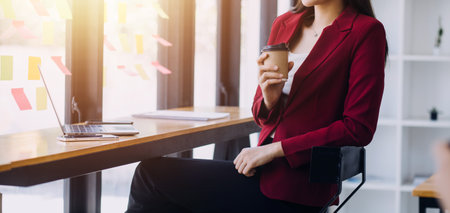 Asian Business woman using calculator and laptop for doing math finance on an office desk, tax, report, accounting, statistics, and analytical research conceptの写真素材