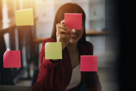 Asian Business woman using calculator and laptop for doing math finance on an office desk, tax, report, accounting, statistics, and analytical research conceptの写真素材