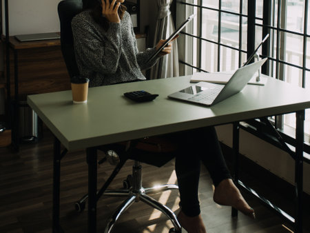 Creative Asian young woman working on laptop in her studio