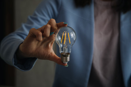 Young adult happy smiling Hispanic Asian student wearing headphones talking on online chat meeting using laptop in university campus or at virtual office. College female student learning remotely.の写真素材