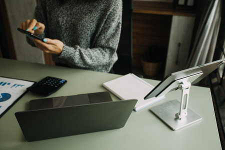 Young adult happy smiling Hispanic Asian student wearing headphones talking on online chat meeting using laptop in university campus or at virtual office. College female student learning remotely.の写真素材