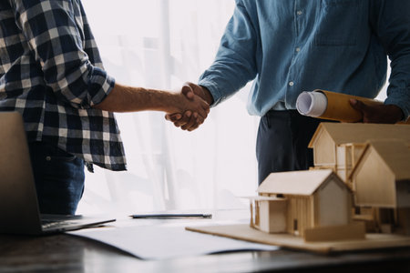 Construction and structure concept of engineer working drawing on blueprint meeting for project working with partner on model building and engineering tools in working site, construction concept.の写真素材