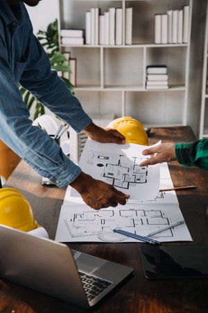 Construction and structure concept of engineer working drawing on blueprint meeting for project working with partner on model building and engineering tools in working site, construction concept.の写真素材