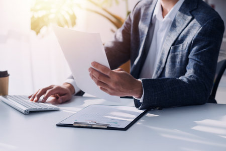 Financial analysts analyze business financial reports on a digital tablet planning investment project during a discussion at a meeting of corporate showing the results of their successful teamwork.の写真素材
