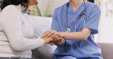 Homecare nursing service and elderly people cardiology healthcare. Close up of young hispanic female doctor nurse check mature caucasian man patient heartbeat using stethoscope during visitの写真素材