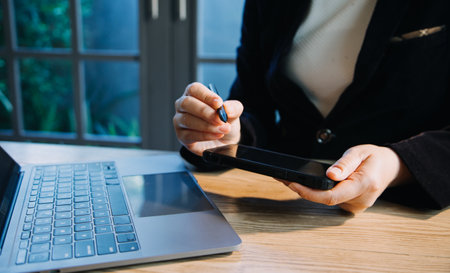 close up hands multitasking man using tablet, laptop and cellphone connecting wifiの写真素材