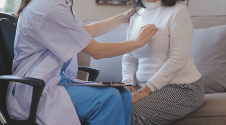 Close up of Doctor using stethoscope to exam heart and lungs of patient woman.の写真素材