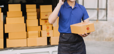 Asian delivery man in cargo van checking boxes.の写真素材