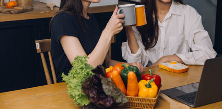Laughing group of diverse young woman hanging out at home together and eating pizzaの写真素材