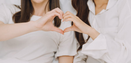 happy teenage girls friend using mobile phone for online shopping in bedroomの写真素材