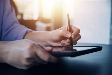 Asian Business woman using calculator and laptop for doing math finance on an office desk, tax, report, accounting, statistics, and analytical research conceptの写真素材