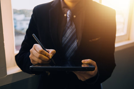 Asian Business woman using calculator and laptop for doing math finance on an office desk, tax, report, accounting, statistics, and analytical research conceptの写真素材