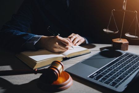 Business and lawyers discussing contract papers with brass scale on desk in office. Law, legal services, advice, justice and law concept picture with film grain effectの写真素材