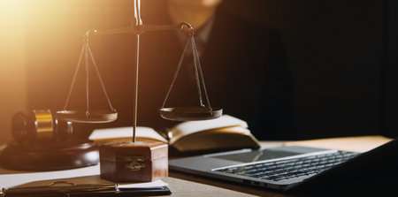 Business and lawyers discussing contract papers with brass scale on desk in office. Law, legal services, advice, justice and law concept picture with film grain effectの写真素材