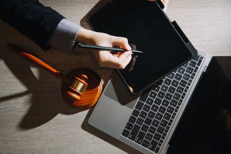 Business and lawyers discussing contract papers with brass scale on desk in office. Law, legal services, advice, justice and law concept picture with film grain effectの写真素材