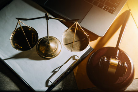 law legal technology concept. judge gavel on computer with scales of justice on desk of lawyer.の写真素材
