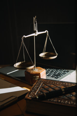 law legal technology concept. judge gavel on computer with scales of justice on desk of lawyer.の写真素材