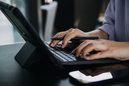 Asian Business woman using calculator and laptop for doing math finance on an office desk, tax, report, accounting, statistics, and analytical research conceptの写真素材