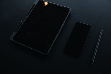Open laptop with digital tablet and white smartphone. All with isolated screen on old wooden desk.の写真素材