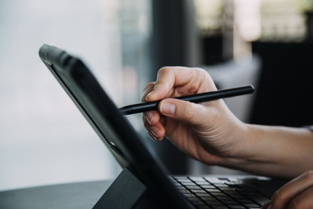Asian Business woman using calculator and laptop for doing math finance on an office desk, tax,...