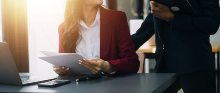 Asian professional successful female businesswoman secretary employee showing information strategy data via laptop notebook computer to male businessman manager in formal business suit in living room.の写真素材