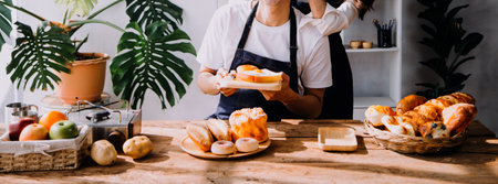 Happy young adult couple making breakfast and drinking coffee together in cozy home kitchen in...