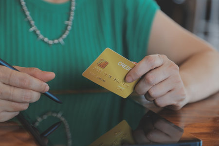 Woman is holding credit card and using laptop computer. Online shopping concept. Close up.の写真素材
