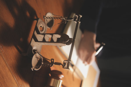 Business and lawyers discussing contract papers with brass scale on desk in office. Law, legal services, advice, justice and law concept picture with film grain effectの写真素材