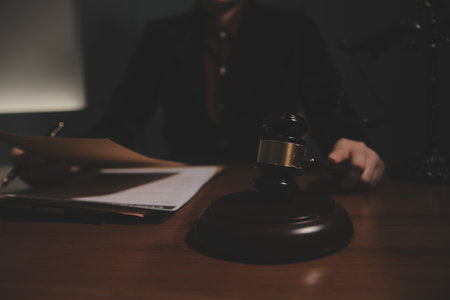 Business and lawyers discussing contract papers with brass scale on desk in office. Law, legal services, advice, justice and law concept picture with film grain effectの写真素材
