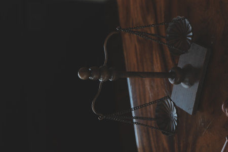 Justice and law concept.Male judge in a courtroom with the gavel, working with, computer and docking keyboard, eyeglasses, on table in morning lightの写真素材