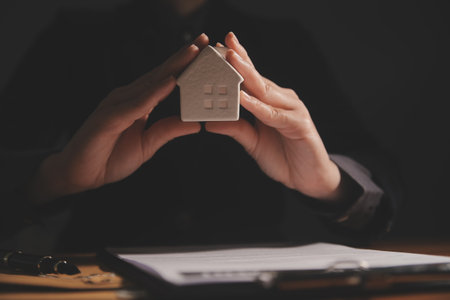 Real estate broker agent presenting and consult to customer to decision making sign insurance form agreement, buy and sell home model, concerning mortgage loan offer for and house insuranceの写真素材