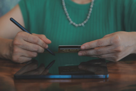 Woman is holding credit card and using laptop computer. Online shopping concept. Close up.の写真素材