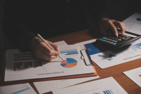 Close up businessman hand using calculator and working with laptop calculate about finance accounting at coffeeshop outdor.finance accounting conceptの写真素材