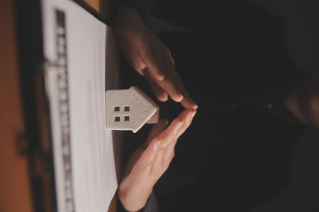 Real estate broker agent presenting and consult to customer to decision making sign insurance form agreement, buy and sell home model, concerning mortgage loan offer for and house insuranceの写真素材