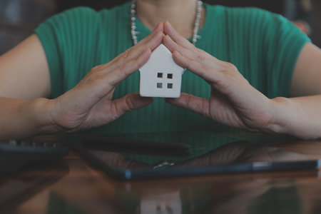Real estate broker agent presenting and consult to customer to decision making sign insurance form agreement, buy and sell home model, concerning mortgage loan offer for and house insuranceの写真素材