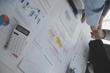 A group of businesspeople and investors meet to discuss market's success in past quarter. idea of setting up a marketing consulting team and working together as a team made it a success.の写真素材